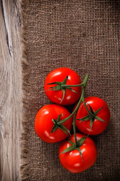 Tuoreet tomaatit säkkikangas — kuvapankkivalokuva