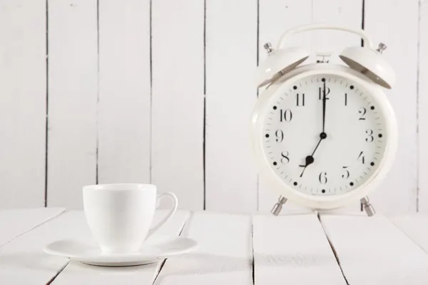 Taza de café y despertador en mesa de madera —  Fotos de Stock