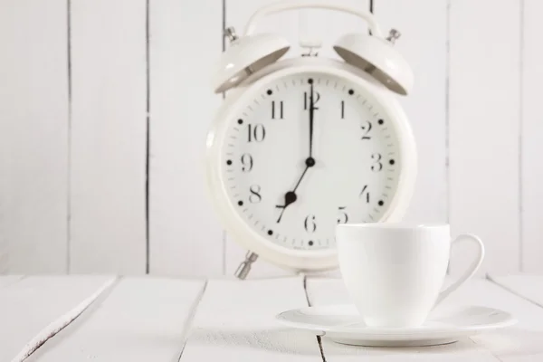 Tazza di caffè e sveglia su tavolo in legno — Foto Stock