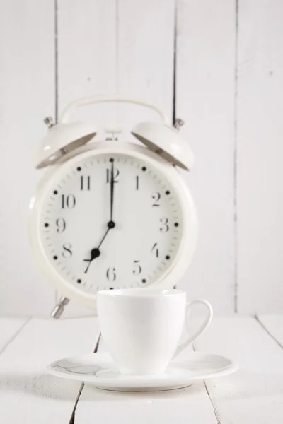 Kopp kaffe och väckarklocka på träbord — Stockfoto