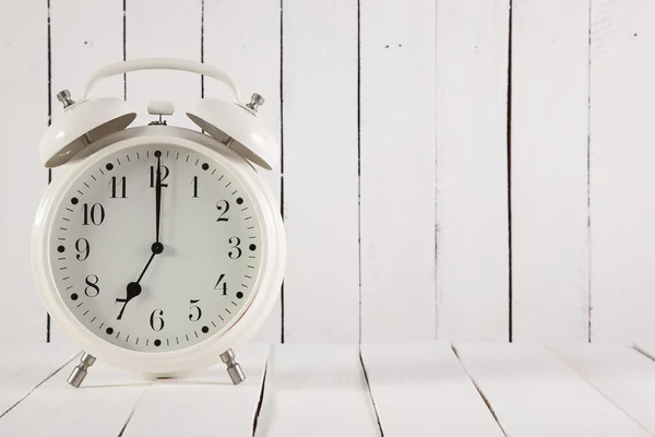 Retro alarm clock on white wooden background — Stock Photo, Image