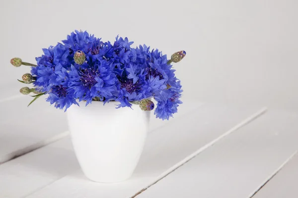 Blauwe korenbloemen in vaas Stockfoto