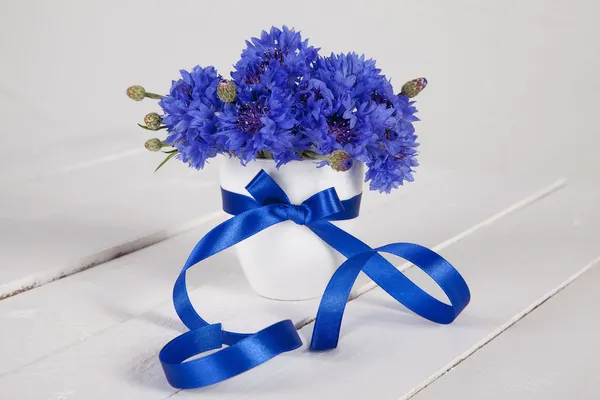 ブルーのリボンと花瓶の青いヤグルマギク ストックフォト