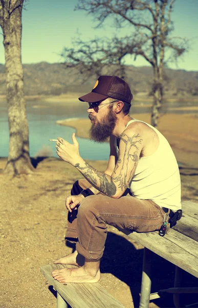 Hipster man with tattoo smokes — Stock Photo, Image