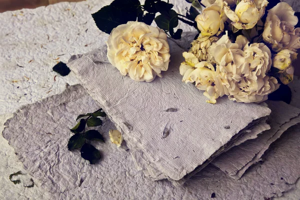 Roses blanches, pétales et papier fait main — Photo
