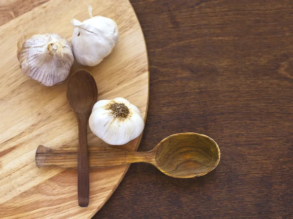 Garlic with wooden spoon — Stock Photo, Image