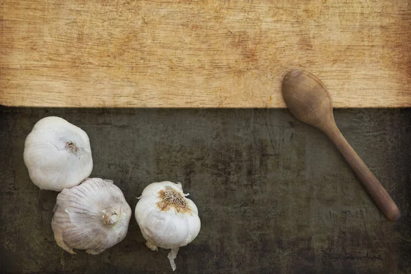 Wooden spoon and white garlic — Stock Photo, Image