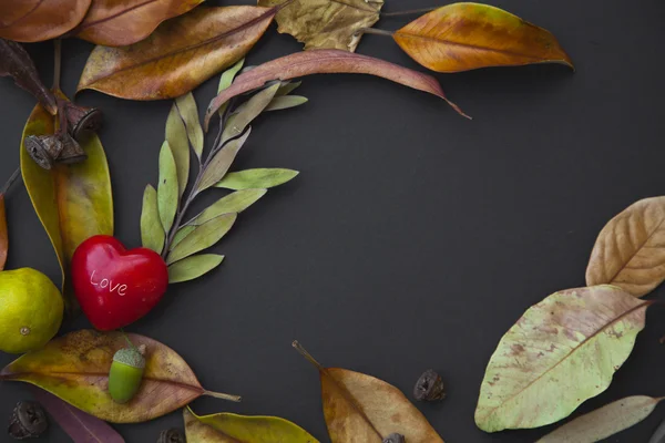 Corazón rojo con hojas de otoño — Foto de Stock