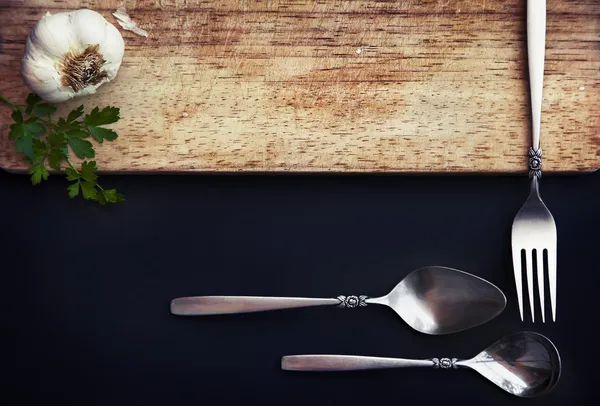 Garlic, parsley, spoon and fork — Stock Photo, Image