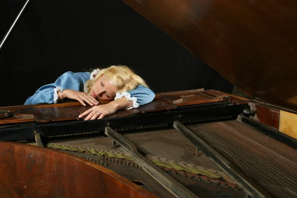 Mulher dormindo no piano de cauda — Fotografia de Stock