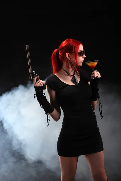 Κόκκινα μαλλιά γυναίκα με ένα πυροβόλο όπλο και ένα κοκτέιλ — Φωτογραφία Αρχείου