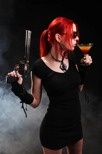 Woman with a gun and a cocktail — Stock Photo, Image