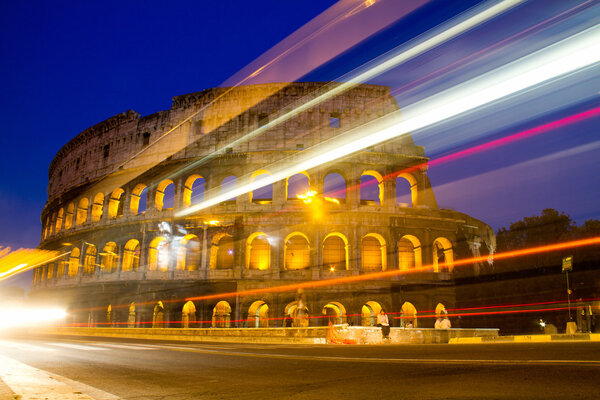 Colosseum in Rome, Italy at night with trails from traffic