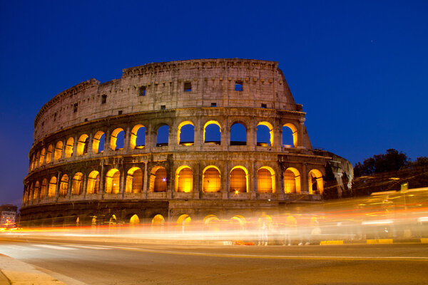 Colosseum in Rome, Italy at night with trails from traffic