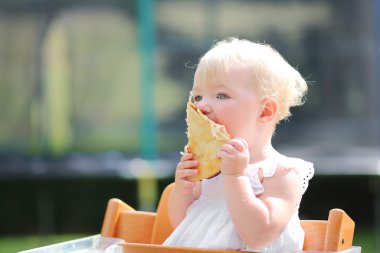 Bebek kız lezzetli pizza bir parçası üzerinde ısırma