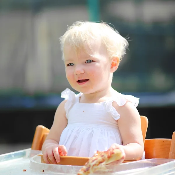 Bebé niña sosteniendo pedazo de pizza deliciosa — Foto de Stock