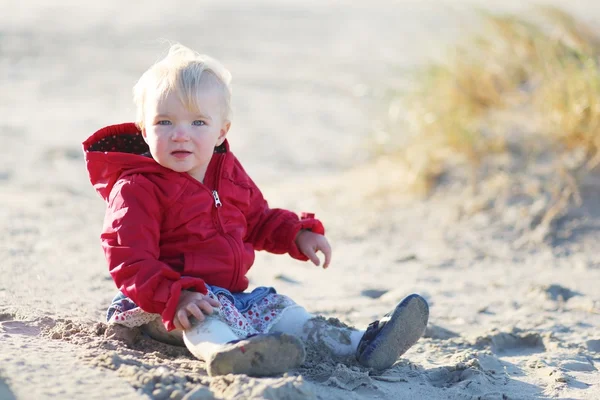 Baby flicka sitter på en sand i sanddynerna — Stockfoto