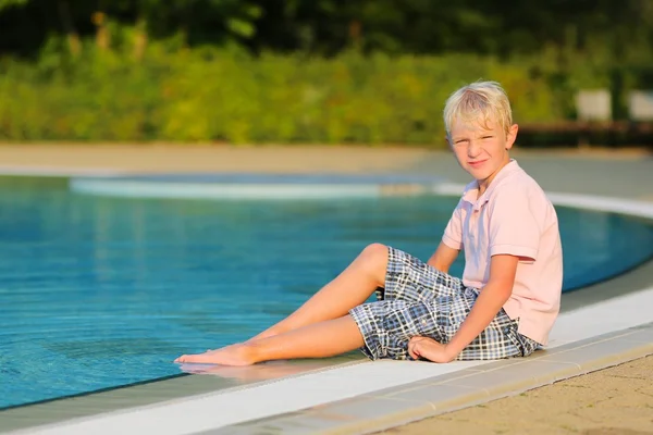 Adolescente menino relaxante na beira de uma piscina — Fotografia de Stock