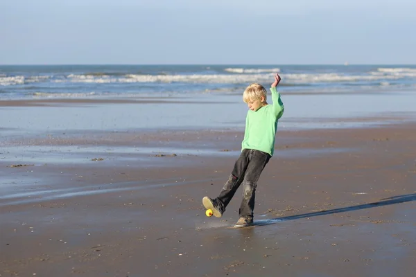 Мальчик играет с мячом на пляже — стоковое фото
