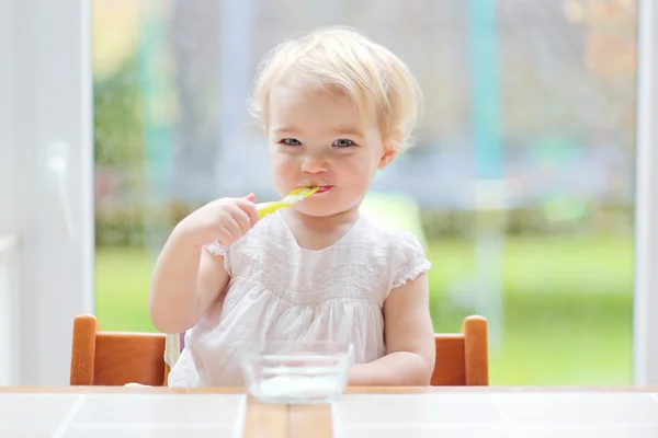 女の子おいしいヨーグルトを食べること — ストック写真