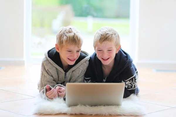 Twin brothers, playing together with notebook — Stock Photo, Image