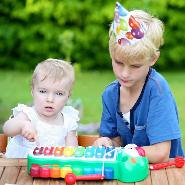 Boy playing with his sister at her first birthday party — Stock Photo, Image