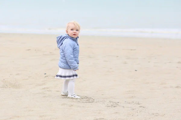 Meisje van de baby wandelingen op herfst zandstrand — Stockfoto