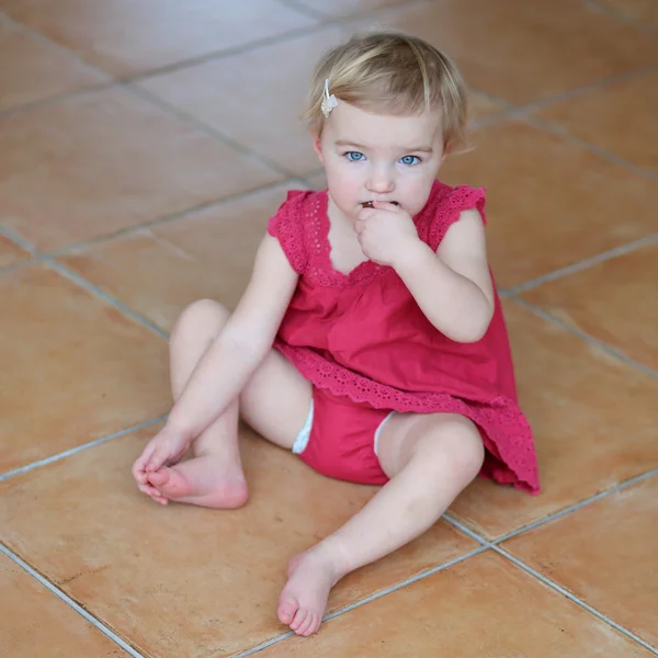 Ragazza mangiare biscotto seduto accogliente su un pavimento di piastrelle — Foto Stock