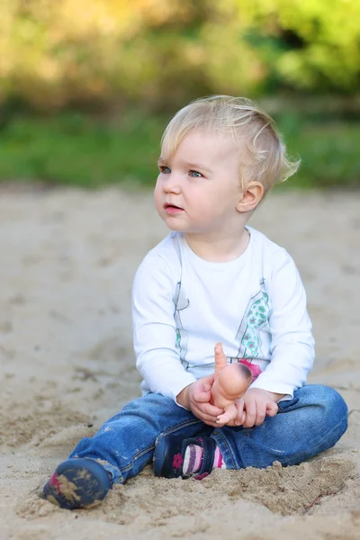 Baby flicka som leker med liten docka — Stockfoto