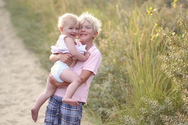 Brother with baby sister  playing together in the dunes — Stock Photo, Image