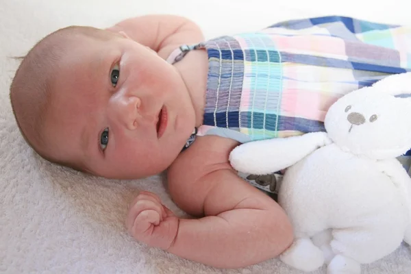 Menina do bebê que coloca com brinquedo de coelho branco — Fotografia de Stock