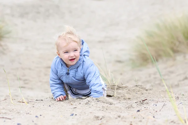 Baby girl plays with sand in the dunes — Stock Photo, Image