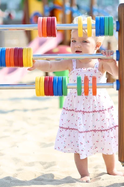 Menina bebê aprendendo a contar com anéis coloridos — Fotografia de Stock