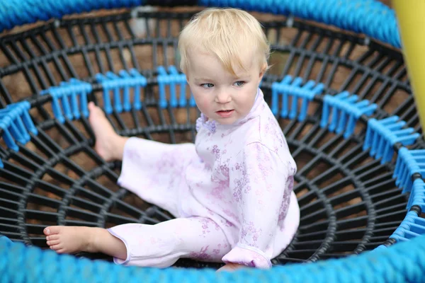 Baby flicka sitter i en gummi netto gunga — Stockfoto