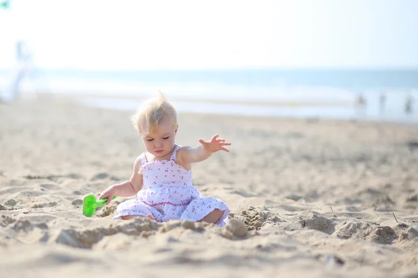 Baby girl sitting at a shore of the sea — Stock Photo, Image