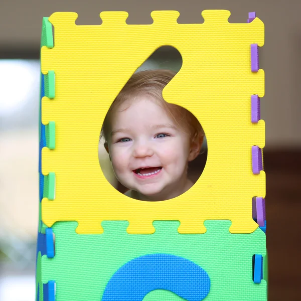 Girl playing hide and seek with colorful numbers puzzles — Stock Photo, Image