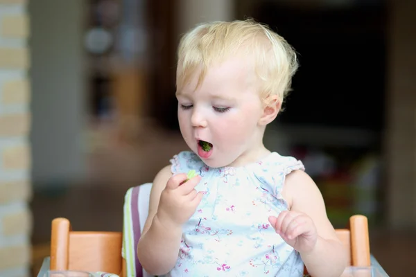 Girl biting on delicious freshly cooked broccoli — Stock Photo, Image