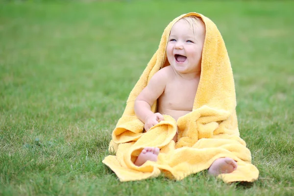 Baby plezier in warme gele handdoek — Stockfoto