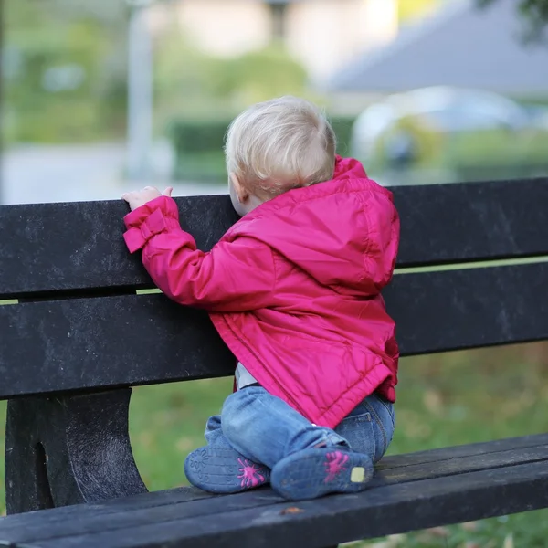 Bebê menina sentado no banco — Fotografia de Stock