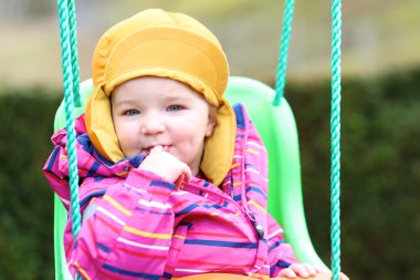 Kız açık havada salıncakta sallanan