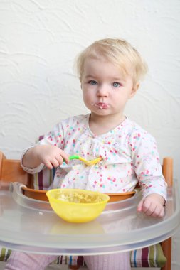 yulaf lapası kaşıkla yiyen kız