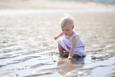 su ve kum ile oynayan kız bebek