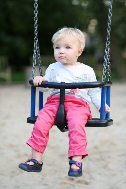 Kız bir salıncak binen eğleniyor