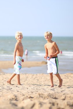 birlikte denize kumsalda yürüyen gençler