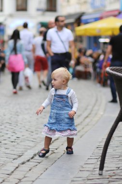yoğun bir kalabalık cadde üzerinde yürüyen kız bebek