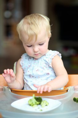 Kız lezzetli taze pişmiş brokoli üzerinde ısırma