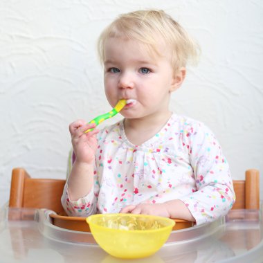 yulaf lapası kaşıkla yiyen kız