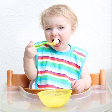 yulaf lapası kaşıkla yiyen kız