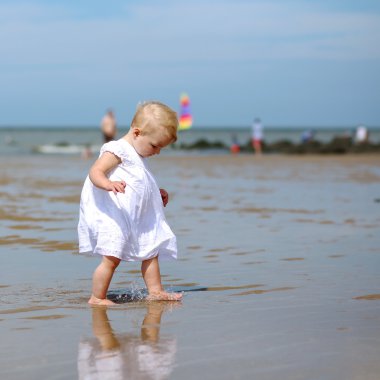 bir kumsalda yürüyen kız bebek