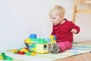 tuğla bina ile oynayan kız bebek